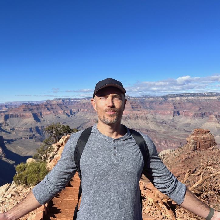 Scott Johns standing outdoors on a hiking trail